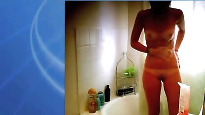 Em lençóis brancos, uma rapariga sem cuecas masturbação filme pornográfico erótico com um vibrador